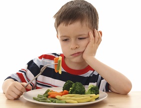 menino com vegetais cozidos