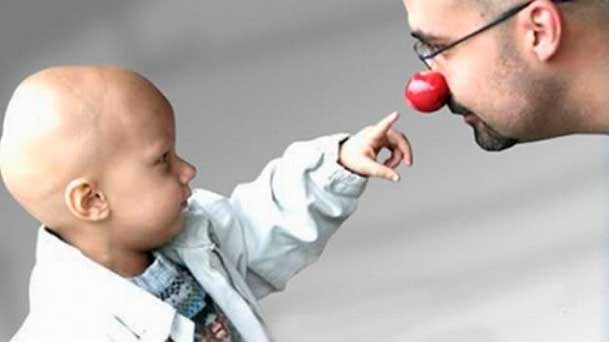 Criança câncer apertando nariz do palhaço
